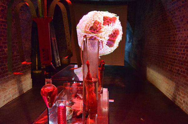 Roter Labortisch und Videoprojektion auf eine schwebende Mattscheibe im Gewölbe der KunstStation Wuppertal