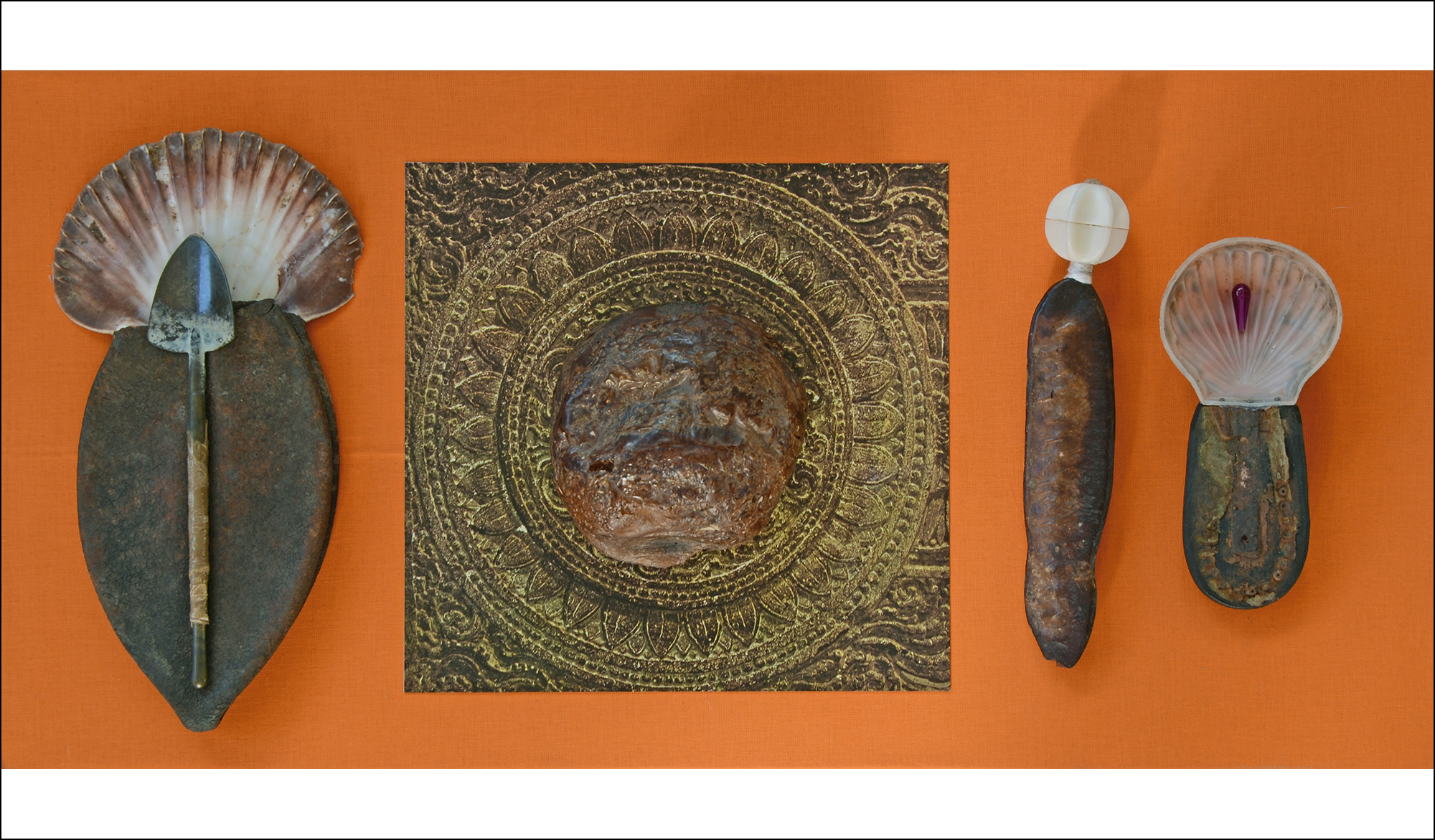 Manipulierte Fundstücke auf einer stoffbezogenen Platte unter Glasvitrine, von Stefan Zöllner